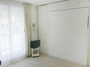 - un salon avec une porte coulissante et une télévision dans l'établissement Apartment Corallo - Utoring-1 by Interhome, à Ascona