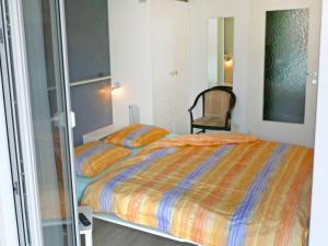 ein Schlafzimmer mit einem Bett und einem Stuhl darin in der Unterkunft Apartment Corallo - Utoring-1 by Interhome in Ascona
