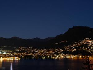 uitzicht op een stad 's nachts vanuit het water bij Apartment Castagnola - Utoring-8 by Interhome in Lugano