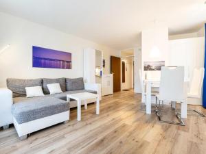 a living room with a couch and a table at Apartment Ferienwohnpark Immenstaad-3 by Interhome in Immenstaad am Bodensee