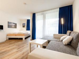 a living room with a couch and a bed at Apartment Ferienwohnpark Immenstaad-3 by Interhome in Immenstaad am Bodensee