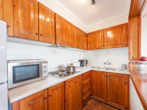 a kitchen with wooden cabinets and a microwave at Apartment Melis-II - 5 by Interhome in Pals