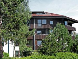 ein großes Gebäude mit einem Balkon und Bäumen in der Unterkunft Apartment Ferienwohnpark Immenstaad-1 by Interhome in Immenstaad am Bodensee