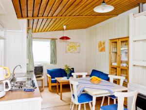eine Küche und ein Esszimmer mit einem Tisch und Stühlen in der Unterkunft Holiday Home Geesthof-1 by Interhome in Klint