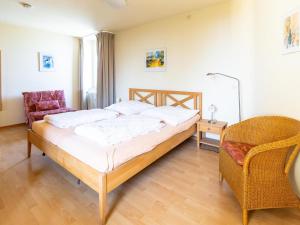 a bedroom with a bed and a chair in it at Apartment Ferienwohnpark Immenstaad-1 by Interhome in Immenstaad am Bodensee