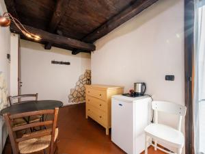 uma cozinha com um frigorífico, uma mesa e cadeiras em Apartment Mansarda by Interhome em Orta San Giulio