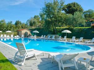 una gran piscina con sillas y sombrillas en Holiday Home Casa Graziani-1 by Interhome, en Ravigliano