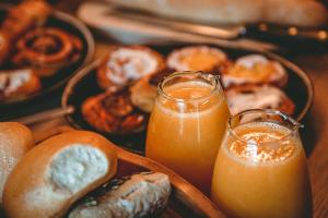 a table with two glasses of orange juice and a tray of donuts at Lit de Clémot in Merelbeke +26 photos
