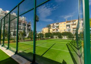 una pista de tenis con red en una pista de tenis en Apartamento Victoria Playa III con una gran terraza, en Denia