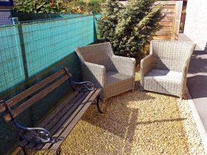 two chairs and a bench next to a fence at Apartment Derby by Interhome in Mispelburg