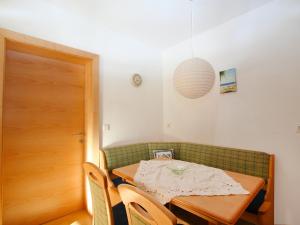 a dining room with a table and a green couch at Apartment Camping Rossbach-1 by Interhome in Nassereith