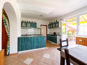 an open kitchen with green cabinets and a table at Apartment Scarlett 1 by Interhome in Balatonőszöd
