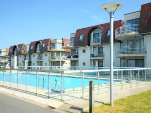 a swimming pool in front of apartment buildings at Apartment Blutsyde Promenade-17 by Interhome in Mispelburg