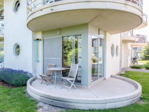a patio with two chairs and a table in front of a building at Apartment Blutsyde Promenade-17 by Interhome in Mispelburg