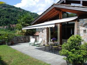 eine Terrasse mit einem Tisch und Stühlen sowie ein Gebäude in der Unterkunft Apartment Cantagallo by Interhome in Vernate