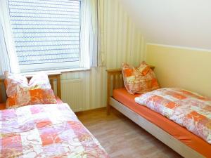 2 Betten neben einem Fenster in einem Zimmer in der Unterkunft Holiday Home Krämer by Interhome in Jever