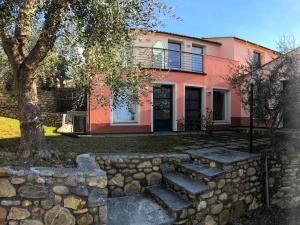 a house with a stone wall and a tree at Studio Borgoverde-11 by Interhome in Imperia