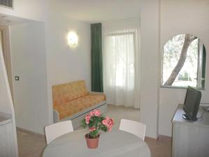 a living room with a couch and a table with flowers at Studio Borgoverde-11 by Interhome in Imperia