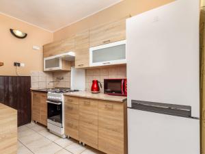 una cucina con armadi in legno e frigorifero bianco di Holiday Home Sunny by Interhome a Balatonkeresztúr