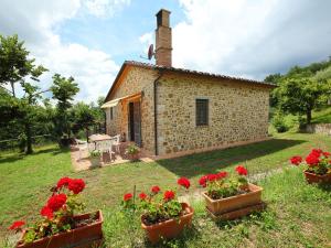 una pequeña casa de piedra con flores rojas delante en Holiday Home Ca' di Bacco-1 by Interhome, en Nestore