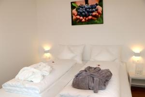 a white bed with two pillows and a picture of fruit at Ipsmiller Appartements in Schrattenberg