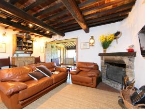 sala de estar con sofá de cuero y chimenea en Holiday Home Casale Verciano by Interhome, en Parrano