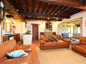 a living room with brown leather furniture and a kitchen at Holiday Home Casale Verciano by Interhome in Parrano