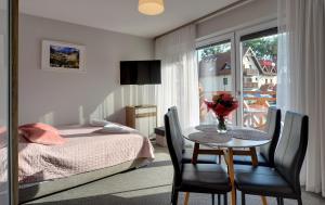 a bedroom with a table and a bed and a window at MATTEO Pensjonat Apartamenty in Duszniki Zdrój