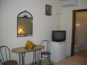 Habitación con mesa, espejo y TV. en b&b Bellavista, en Castro di Lecce