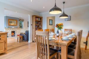 a dining room and living room with a table and chairs at Woodside Cottage in Chipping Campden