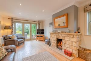 a living room with a fireplace and a couch at Woodside Cottage in Chipping Campden