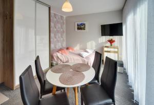 a room with a table and chairs and a bed at MATTEO Pensjonat Apartamenty in Duszniki Zdrój
