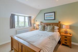 a bedroom with a large bed and a window at Woodside Cottage in Chipping Campden