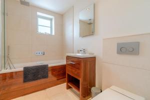 a bathroom with a tub and a sink and a mirror at Woodside Cottage in Chipping Campden +26 photos