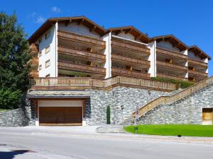 a large apartment building with a garage at Apartment Antares by Interhome in Crans-Montana