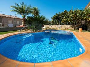 a large swimming pool with blue water in a yard at Holiday Home Juan by Interhome in Segur de Calafell