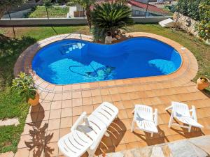 una piscina con 2 tumbonas y una piscina en Holiday Home Juan by Interhome, en Segur de Calafell