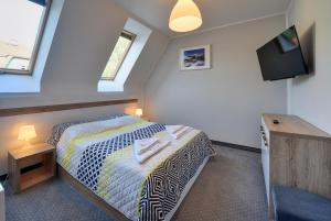 a bedroom with a bed and a tv in a room at MATTEO Pensjonat Apartamenty in Duszniki Zdrój +86 photos