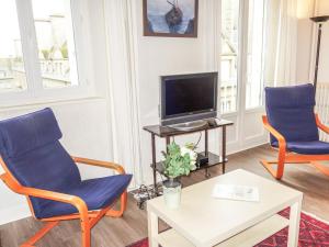 een woonkamer met twee stoelen en een tv bij Apartment Beauchesne by Interhome in Saint-Malo