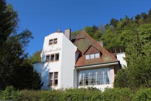 ein weißes Gebäude mit rotem Dach in der Unterkunft Kurvilla am Park in Bad Kissingen