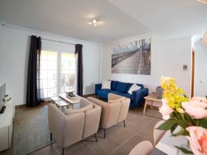 ein Wohnzimmer mit einem blauen Sofa und Stühlen in der Unterkunft Holiday Home Luz del Sol by Interhome in Calpe