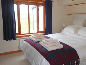 a bedroom with a bed with towels on it at Holiday Home Fiskavaig by Interhome in Fiskavaig