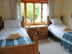 a bedroom with two twin beds and a window at Holiday Home Fiskavaig by Interhome in Fiskavaig +11 photos