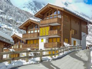 um grande edifício de madeira nas montanhas com neve em Apartment La Prairie by Interhome em Zermatt