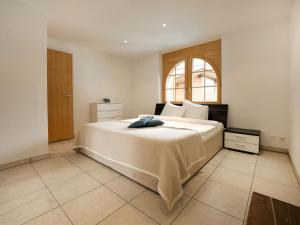 Schlafzimmer mit einem großen weißen Bett und einem Fenster in der Unterkunft Apartment La Prairie by Interhome in Zermatt