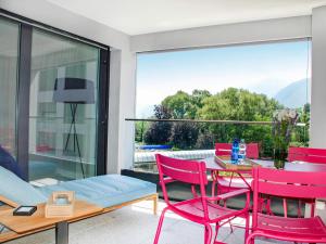 a living room with red chairs and a table at Apartment LaVille A-3-4 by Interhome in Locarno
