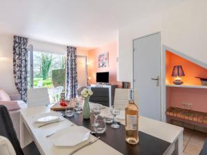 una sala da pranzo con tavolo e bottiglia di vino di Holiday Home Les Cottages du Golf-3 by Interhome a Ploemel