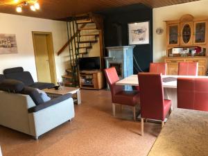 ein Wohnzimmer mit einem Tisch und roten Stühlen in der Unterkunft Holiday Home Norderney by Interhome in Norddeich