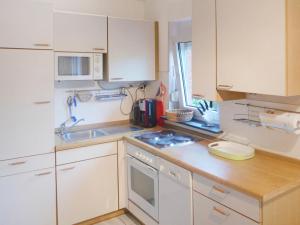eine kleine Küche mit weißen Schränken und einem Waschbecken in der Unterkunft Holiday Home Norderney by Interhome in Norddeich