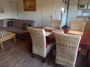 ein Wohnzimmer mit einem Tisch, Stühlen und einem Sofa in der Unterkunft Holiday Home Norderney by Interhome in Norddeich